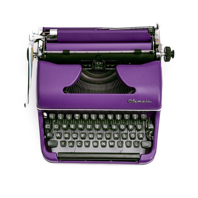 May include: A purple vintage typewriter with a black keyboard and the word "Olympia" printed on the front.