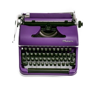 May include: A purple vintage typewriter with a black keyboard and the word "Olympia" printed on the side.
