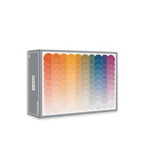 May include: A box for a 500 piece jigsaw puzzle with a colorful abstract design of overlapping circles in shades of orange, yellow, green, blue, and purple. The box is labeled "CASCADE POSTER PUZZLES".