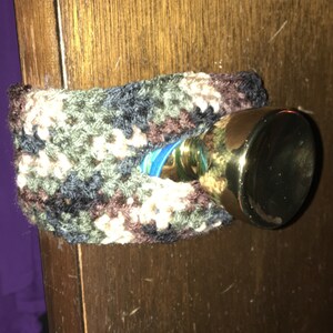 May include: A camouflage crocheted door knob cover with a gold door knob.