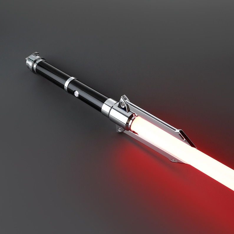 May include: A black and silver lightsaber with a red blade. The lightsaber is turned on and the blade is glowing.