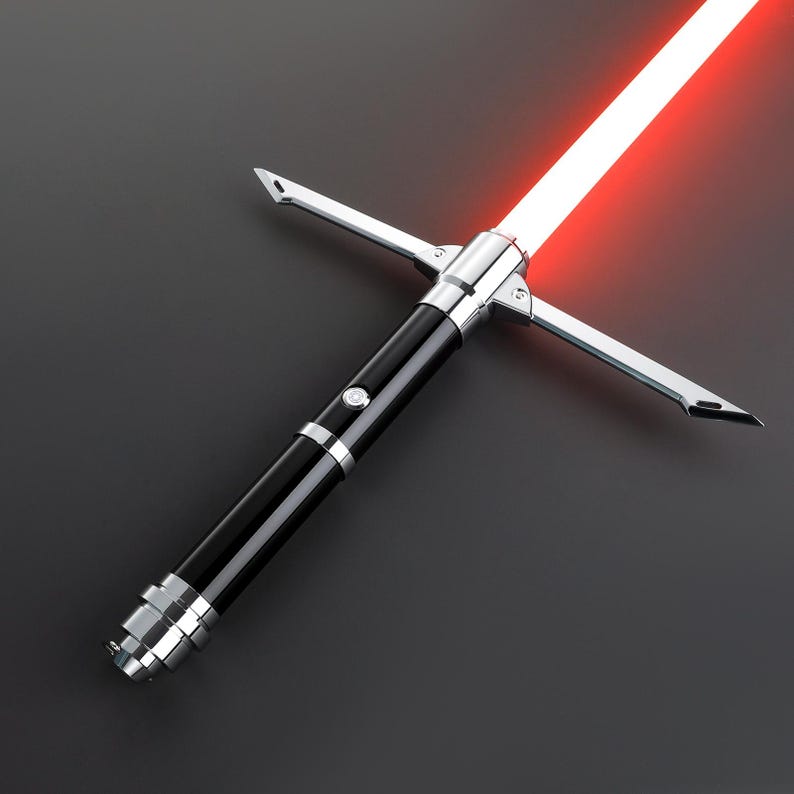 May include: A black lightsaber with a silver handle and a red blade. The lightsaber has a crossguard design with two silver blades extending from the handle.