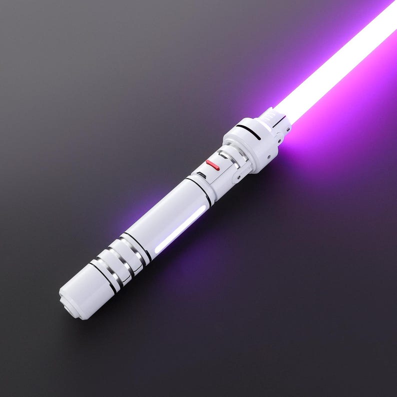 May include: A white lightsaber with a purple blade. The lightsaber has a silver accent and a red button.