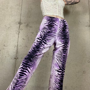 May include: Purple and black zebra print pants with a wide leg and a cropped length.