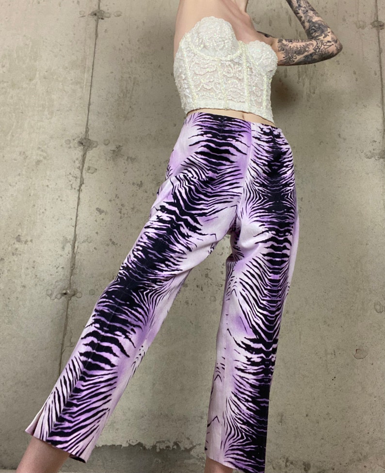 May include: Purple and black zebra print pants with a wide leg and a cropped length.