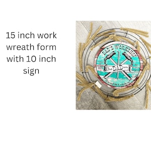 May include: A 15 inch work wreath form with a 10 inch round sign that says "Dad's Workshop" with a turquoise background and crossed hammers. The sign says "Fixer of broken toys and broken hearts. Best Dad ever. It can't be fixed, nobody can."