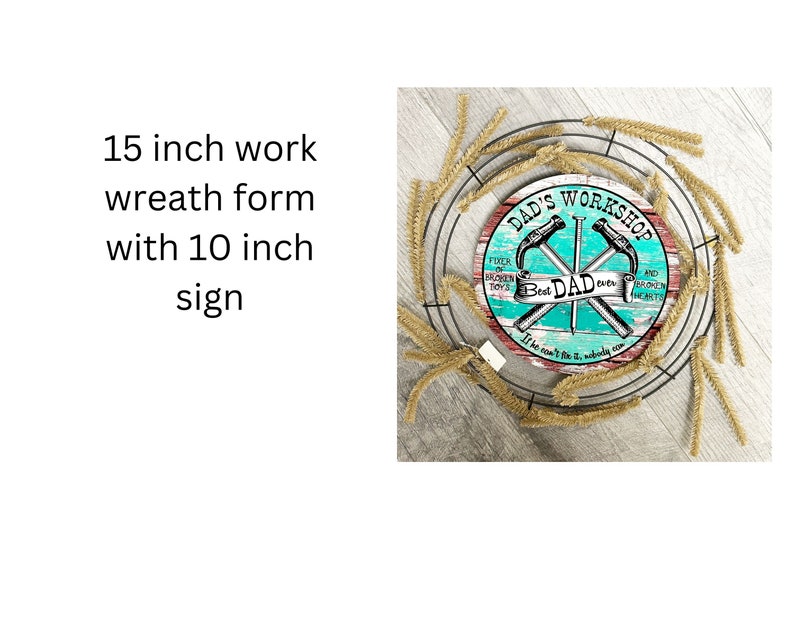 May include: A 15 inch work wreath form with a 10 inch round sign that says "Dad's Workshop" with a turquoise background and crossed hammers. The sign says "Fixer of broken toys and broken hearts. Best Dad ever. It can't be fixed, nobody can."