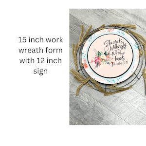 May include: A 15-inch work wreath form with a 12-inch sign that says "She Works Willingly With Her Hands Proverbs 31:13". The sign has a floral design with pink, blue, and green colors.