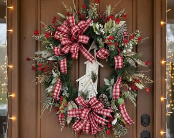 May include: A festive Christmas wreath with a white church centerpiece, red berries, and plaid ribbons. The wreath is adorned with greenery and a pinecone, creating a welcoming holiday decoration for a front door.