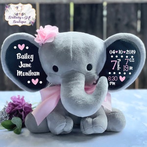 May include: Gray plush elephant with pink ribbon and flower, personalized with the name Bailey Jane Monikan, birth date 04-10-2019, time 6:30 PM, weight 7 oz, and length 19 in.