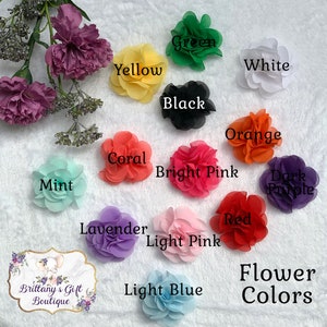 Op de afbeelding: Een assortiment van stoffen bloemenversieringen in verschillende kleuren, waaronder groen, geel, wit, zwart, oranje, koraal, felroze, donkerpaars, mint, rood, lavendel, lichtroze en lichtblauw. De bloemen zijn in een cirkel op een wit oppervlak gerangschikt. De tekst "Bloemkleuren" staat onder de bloemen.