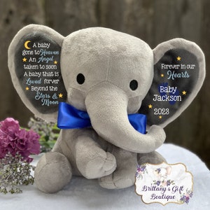 Puede incluir: Un elefante de peluche gris con una pajarita azul. El elefante tiene texto bordado en sus orejas, incluyendo "A baby gone to Heaven, An Angel taken to soon, A baby that is Loved forever, Beyond the Stars & Moon" y "Forever in our Hearts, Baby Jackson, 2023".