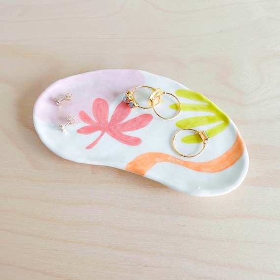 Hand-built ceramic dish with abstract floral paintwork — each one genuinely one-of-a-kind, the kind of thing you'd spot in a boutique and wonder where it came from.