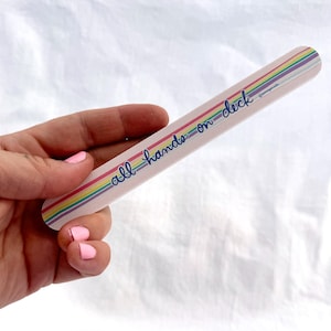 May include: A pink nail file with rainbow stripes and the text "all hands on deck".