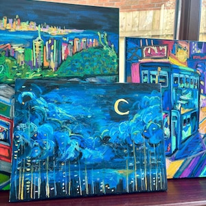 K&ouml;nnte beinhalten: Eine Sammlung farbenfroher Stadtlandschaftsbilder. Die Kunstwerke zeigen lebendige Darstellungen von Stadtlandschaften, darunter Geb&auml;ude, B&auml;ume und einen Nachthimmel mit einem Halbmond. Die Gem&auml;lde verwenden eine Vielzahl von Farben und Texturen.