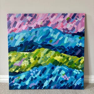 Puede incluir: Pintura abstracta de paisaje con capas de pinceladas coloridas. La obra de arte muestra una paleta vibrante de azules, verdes y rosas, creando un efecto visual texturizado y din&aacute;mico. La pintura est&aacute; montada sobre un lienzo cuadrado.