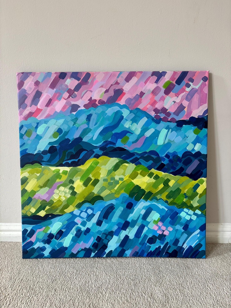 Puede incluir: Pintura abstracta de paisaje con capas de pinceladas coloridas. La obra de arte muestra una paleta vibrante de azules, verdes y rosas, creando un efecto visual texturizado y din&aacute;mico. La pintura est&aacute; montada sobre un lienzo cuadrado.