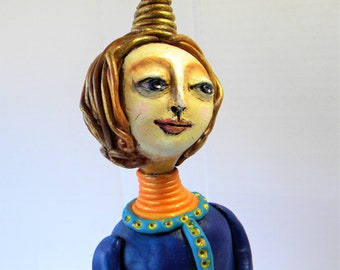 Whimsical clay sculpture of a woman praying