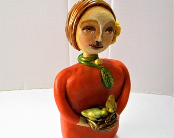 Clay girl whimsical sculpture with a bird's nest