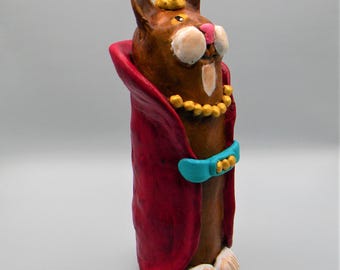 Clay cat sculpture dressed in a royal red robe and crown