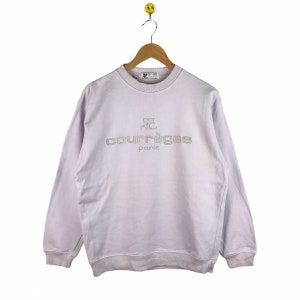 Pu&ograve; includere: Una felpa di colore lavanda con un logo ricamato bianco che dice "Courr&egrave;ges Paris".