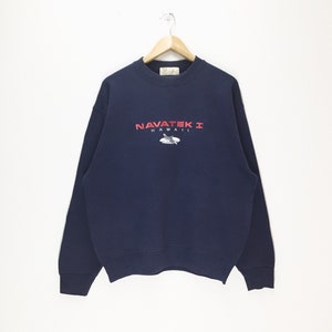May include: A navy blue sweatshirt with a red embroidered logo that says "NAVATEK I HAWAII" with a small image of a surfboard and a seagull.