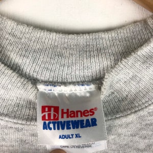 May include: Gray Hanes Activewear t-shirt tag with the text "Hanes Activewear" and "Adult XL".