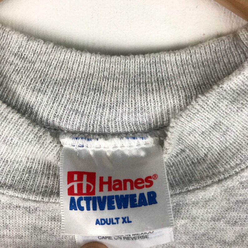 May include: Gray Hanes Activewear t-shirt tag with the text "Hanes Activewear" and "Adult XL".