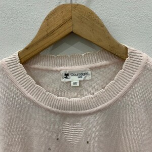 May include: A pale pink knitted sweater with a heart design and a Courr&egrave;ges Paris label. The label has the size 9R printed on it.