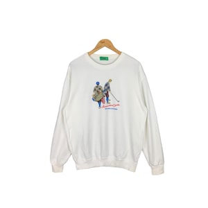 May include: White sweatshirt with a graphic of two golfers and the text "International Golf, Special Ballenders".