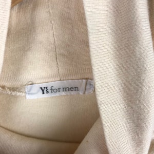 May include: A white turtleneck sweater with a white label that reads "Y's for men".