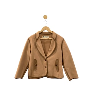 May include: A brown blazer with a brown trim and two pockets. The blazer has a label that says "Darling".
