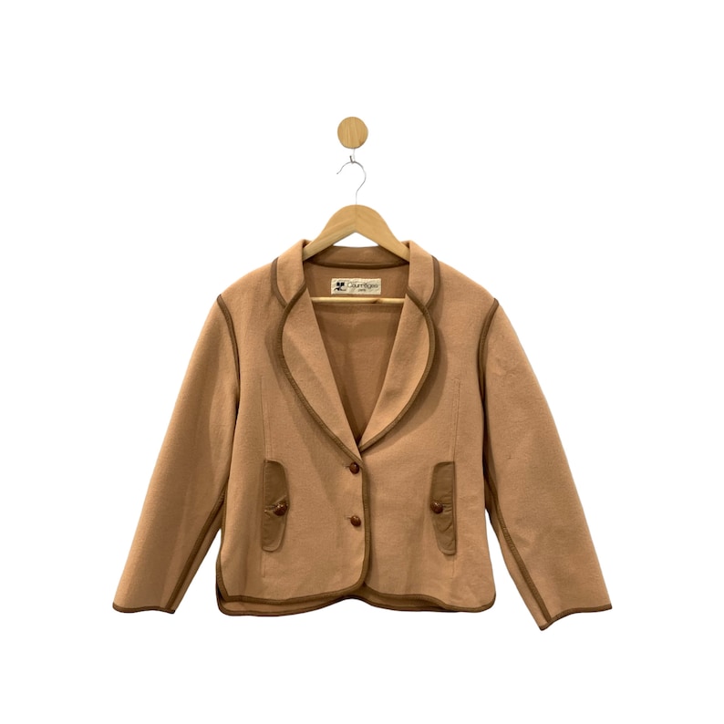 May include: A brown blazer with a brown trim and two pockets. The blazer has a label that says "Darling".
