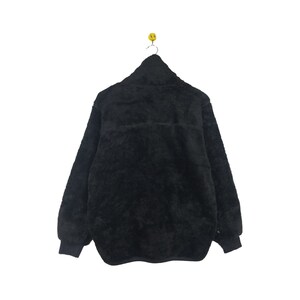 May include: A black fleece jacket with a zipper closure. The jacket has a soft, fuzzy texture.