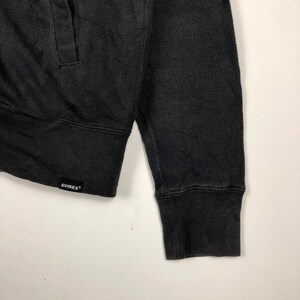 May include: Black long-sleeve sweatshirt with a ribbed cuff and a black label with the text "AVIREX" on the bottom left side.