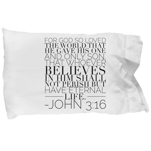 May include: White pillow with black text that reads "For God so loved the world that he gave his one and only son, that whoever believes in him shall not perish but have eternal life. -John 3:16"