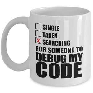 May include: White ceramic coffee mug with black text that reads "Single, Taken, Searching for someone to debug my code". The word "Searching" is checked off with a red X.