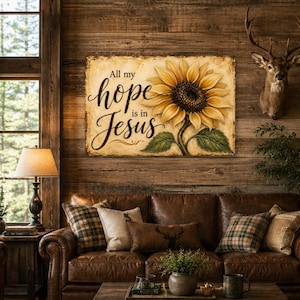 May include: A rectangular wall art print featuring a large yellow sunflower with green leaves on a textured beige background. The text "All my hope is in Jesus" is written in black cursive script on the left side of the sunflower illustration.