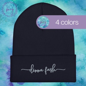 May include: Navy blue beanie with the text "dimma fosh" embroidered in silver on the front. The beanie is made of a soft, knitted fabric and has a fold-over cuff. The beanie is shown against a blue and green watercolour background.