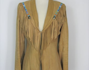 May include: A tan suede jacket with fringe detailing and beaded trim around the collar. The jacket has a V-neck and a button closure.