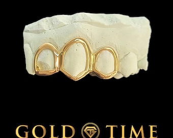 May include: Gold grill with four teeth, made of solid gold. The grill is displayed on a white mold.