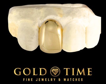 May include: A single polished gold tooth cap fitted over a white dental mold of three teeth. Below the dental piece, the text reads GOLD TIME FINE JEWELRY & WATCHES with a circular logo featuring the letters GT inside a diamond shape.