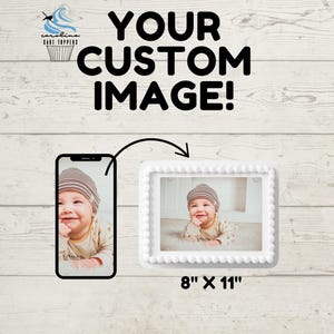 May include: White cake topper with a white frame and a photo of a baby wearing a brown and white hat. The cake topper is 8 inches by 11 inches. "Your Custom Image!" is written in black text above the cake topper.