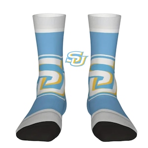 May include: A pair of crew socks in light blue, white, and yellow. The socks feature a repeating design with the letters "SD" in a stylized font. The toes and heels are black, and the cuffs are white.