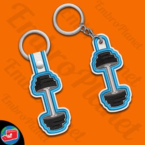 May include: Two keychains featuring a blue and black barbell design. The keychains are made from fabric and have a silver metal ring.
