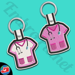 May include: Two embroidered keychains featuring a pink and white scrubs design with a stethoscope. The keychains are attached to silver key rings.