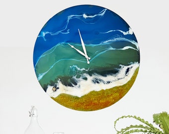 Può includere: Un orologio rotondo in resina con un design astratto blu, verde, bianco e arancione che ricorda un'onda oceanica. Le lancette dell'orologio sono bianche e il quadrante dell'orologio è vuoto.