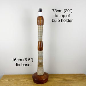 May include: A tall lamp base featuring alternating sections of polished dark brown wood and light-colored, horizontally striped material. It stands 73 cm (29 inches) to the top of the bulb holder with a 16 cm (6.5 inches) diameter base.
