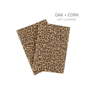 Könnte beinhalten: Zwei Blätter braunes Geschenkpapier mit Leopardenmuster. Das Papier ist mit "Oak + Cork Soft Leopard" beschriftet.