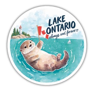 Peut inclure: Un autocollant circulaire représentant une loutre brune flottant dans une eau turquoise, tenant un petit drapeau canadien. En arrière-plan, un phare se dresse sur une rive rocheuse. Le texte indique LAKE ONTARIO always and forever avec un cœur.